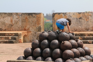 Child climbing on cannon balls in fort el morro